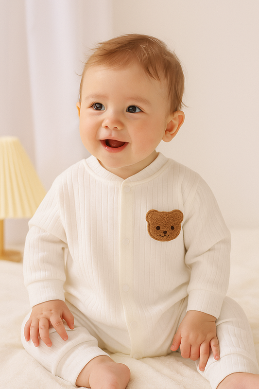 Baby jumpsuit - Onesies - Romper. Med björnbrodering på vänster bröst, Vit. Modellbild sittande barn