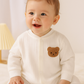 Baby jumpsuit - Onesies - Romper. Med björnbrodering på vänster bröst, Vit. Modellbild sittande barn